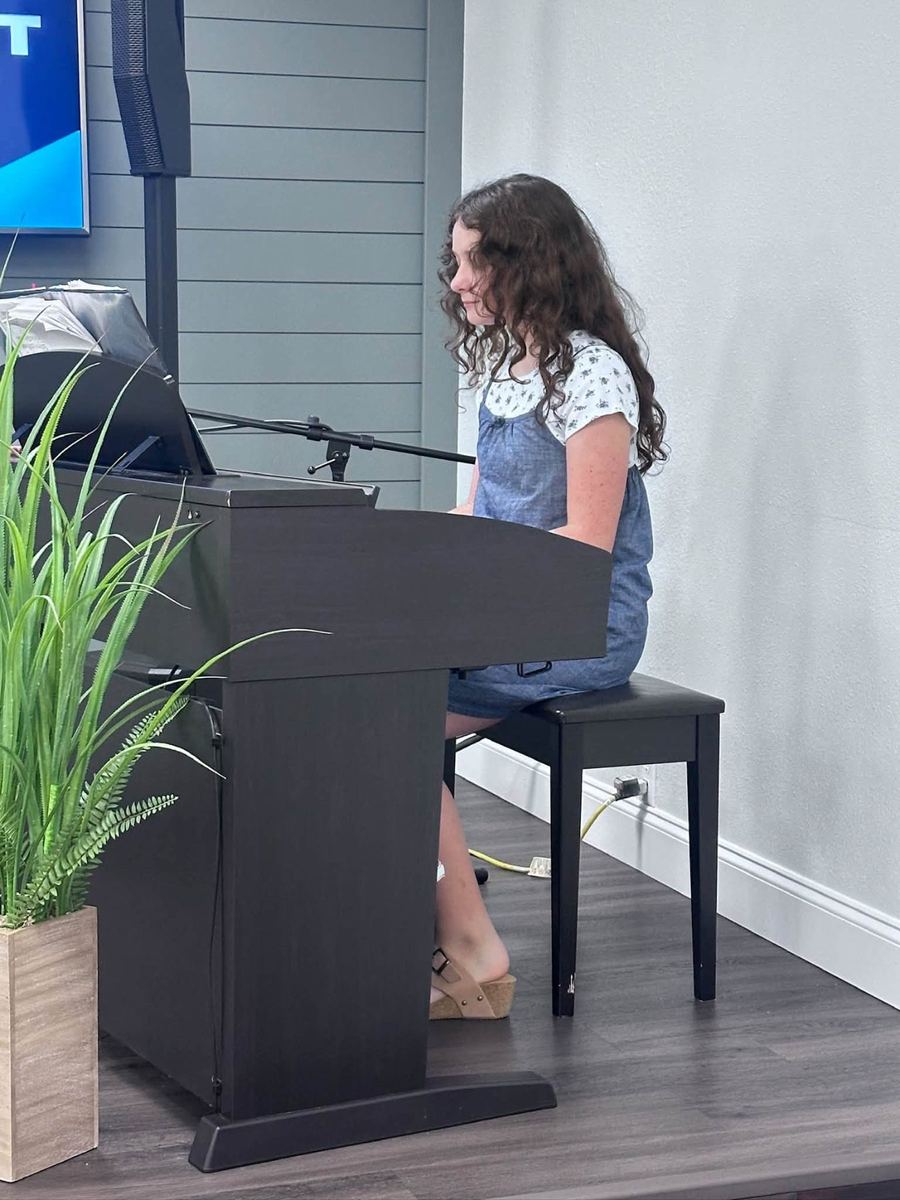 A young girl playing piano during a service