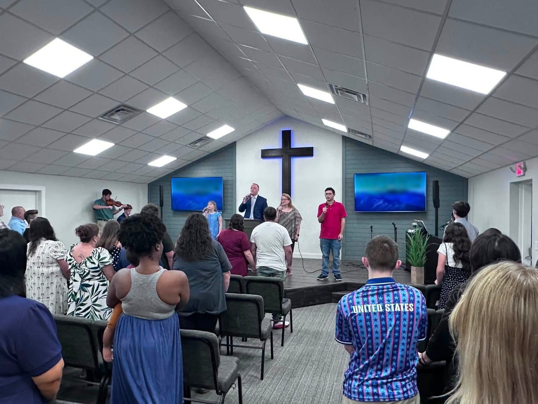 The congregation standing to sing during a service